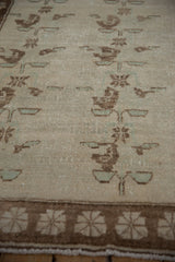 Low angle detail of the short pile and coffee brown floral sprays on a vintage Oushak rug.