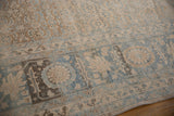 Distressed vintage Tabriz carpet showing abrash, faded beige, and powder blue Herati pattern.
