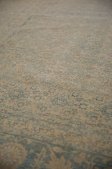 Distressed vintage Tabriz carpet, showing worn beige and dusty blue Herati pattern.