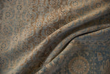 Folds reveal distressed Tabriz carpet with fine Herati pattern, showing beige and blue abrashes.