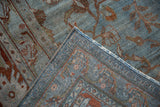 Distressed Bibikabad carpet corner showing blue and terracotta vinery, visible pile wear, and detailed knotted back.
