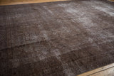 Textural detail of vintage Sparta rug with distressed brown and charcoal hues and faded patterns.