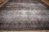 Textured brown and charcoal vintage Sparta rug showing light foundation through wear.