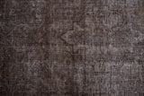 Brown and charcoal distressed vintage Sparta rug showing worn pile and oxidized silver foundation.