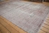 Faded ivory and dusty raspberry tones on distressed Sparta rug, with foundation showing.