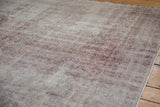 Distressed vintage Sparta rug showcasing exposed foundation and faded ivory and dusty raspberry hues.