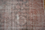 Distressed Sparta carpet texture showing exposed foundation, pale raspberry and silver hues.