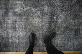 Textured wear across a vintage Sparta carpet revealing knot heads in teal and white.