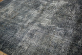 Distressed texture of the vintage Sparta carpet, revealing dark teal, navy, and oxidized silver.
