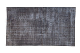 Distressed Sparta rug, oxidized silver and charcoal tones, with subtle medallion and aged texture, 3'6