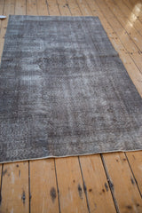Distressed Sparta rug with aged texture, highlighting mostly even wear and charcoal, silver tones.