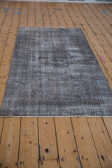 Secured end of the vintage Sparta rug, highlighting distressed charcoal and silver texture.