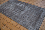 Detail of the vintage distressed Sparta rug's textured pile, showing time-softened silver and charcoal.