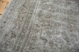 Worn pile of vintage Meshed rug, showing faded oxidized silver, ivory, and chocolate brown patterns.