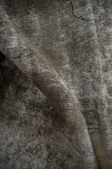 Textural view of a vintage overdyed Meshed carpet, showing worn foundation and faded colors.