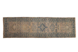 A distressed vintage Karaja rug runner with a column of geometric medallions in dusty blue on an antique ivory field.