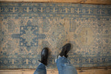 View from above of the distressed Karaja rug runner's low pile and geometric pattern in dusty blue and beige.