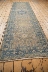 Angled view down the length of a vintage Karaja runner with a distressed, low pile.