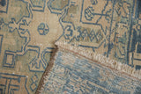 Folded corner of a distressed Karaja rug showing its hand-knotted foundation and low pile.