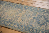 Close-up of a Karaja runner's geometric border and distressed, low pile texture in dusty blue.