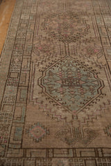 Distressed Serab runner detail: geometric medallions, hook and latch motif, soft aqua, pink, and worn pile.