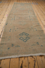 Angled shot of a distressed vintage runner highlighting its worn, low-pile texture and repeating pattern.