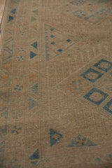 The low, even wear of a distressed Persian runner, showing the texture of the knot heads.