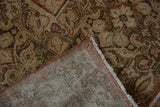 Distressed Sarouk carpet displaying worn floral pile and visible hand-knotted foundation.