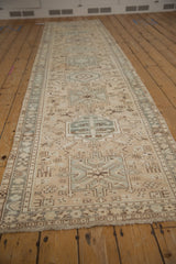 Distressed Karaja runner's geometric motifs and patterned border in beige, slate blue, and brown.