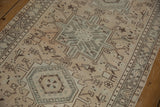 Distressed geometric patterns of a vintage Karaja runner in beige and charcoal with visible wear.