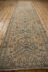 Distressed vintage Karaja rug runner showing geometric animals, shrubs, dusty blue motifs, and fringe.
