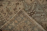 Distressed Karaja runner corner showing beige, blue, and brown geometric pattern and intact selvage.