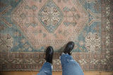 Vintage Distressed Persian Abadeh rug's worn pile, geometric pattern in dusty blue and muted mauve.
