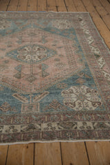 Detail of distressed vintage Abadeh rug, with geometric blossoms and border in dusty mauve and blue.