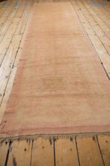 Angled view down the length of the vintage Oushak runner, showing its soft pink and sand palette.