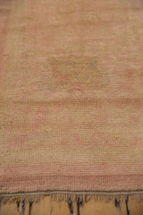 Close-up of the pronounced, time-worn patch on the hand-knotted pile of a distressed Oushak runner.