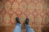 Distressed vintage Oushak rug featuring faded dusty rose and gold elephant footprint medallions.