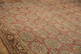 Distressed vintage Oushak rug close-up showing meandering vine border and elephant footprint medallions.