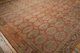 Distressed vintage Oushak carpet corner, showing dark chocolate border and faded elephant footprint medallions.