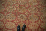 Distressed Oushak carpet texture with faded elephant footprint motifs, dusty rose, gold.