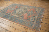 Distressed vintage Veece rug corner, abrashed blush and sky blue, worn pile and selvage.