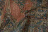 Distressed Persian Veece rug texture, revealing blush, blue, and gold geometric motifs with even wear.