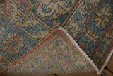 Curled corner of Veece rug reveals distressed pile, woven foundation, and intact blush selvage.