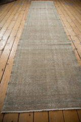 A long view of a distressed Hamadan runner showing its silvery patina and time-softened tones.