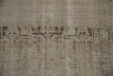 Close-up of the distressed Hamadan runner's low pile and visible hand-knotted foundation.