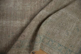 Detailed texture of the distressed silver pile revealing the hand-knotted foundation.