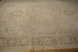 Distressed Heriz carpet with even wear, geometric border, and muted seafoam green tones.