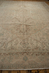 Distressed Vintage Heriz rug, showing border with muted geometric pinwheel patterns and fringe.