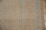 Distressed beige wool field with dusty blue Herati motifs and linear border.