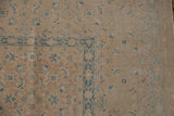 Distressed Birjand carpet pile showing sand, beige, and dusty blue Herati patterns.